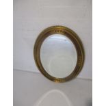 A gilt framed oval bevel edged mirror. A/F