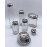 A collection of 7 silver topped dressing table pots