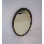 A Victorian mahogany framed oval wall mirror, with bevelled edge.