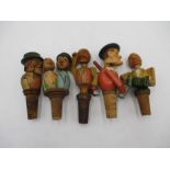 A collection of five novelty articulated wooden bottle stoppers