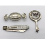 A hallmarked silver pill box in the form of a sweet along with a silver miniature hand mirror and