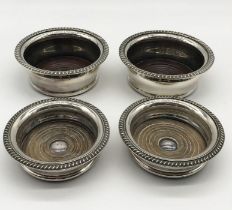 Two pairs of silver plated wine coasters, one pair with mark