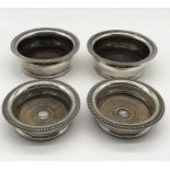 Two pairs of silver plated wine coasters, one pair with mark