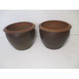 A pair of large glazed terracotta garden pots.