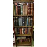A collection of various vintage and antiquarian books over four shelves