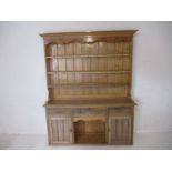 A pine dresser, with three drawers and two cupboards under, length 175cm, height 212cm.