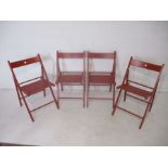 A set of four matching Ikea "Terje" red folding chairs
