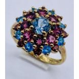 A 9ct gold multi coloured cluster ring set with garnets and topaz