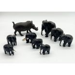 A collection of wooden elephants along with a carved wooden warthog