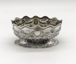 A hallmarked silver basket decorated with swags, shaped rim and repousse work, London 1884, weight