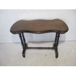 A Victorian centre table with ebonised base and shaped top with inlaid detail