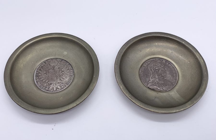 A pair of 800 continental silver dishes with a split silver Marie Theresa Thaler dated 1780