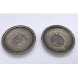 A pair of 800 continental silver dishes with a split silver Marie Theresa Thaler dated 1780