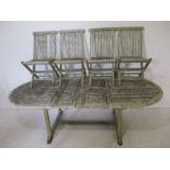 A large weathered wooden extending garden table with four matching chairs. Overall table size -