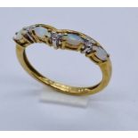 An opal and diamond half eternity ring set in 9ct gold