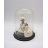 A pin cushion doll, along with a peg doll by Joan Fairgrieve Langport, under a glass dome