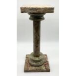 A square topped onyx torchere on a turned column and stepped circular base, on a square plinth,