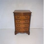 A serpentine front burr walnut small chest of four drawers, with brush tray.