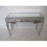 A mirrored side table, with three drawers, length 127cm, height 83cm.