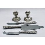 A pair of hallmarked silver dwarf candlesticks and three silver handled items