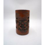 An Oriental bamboo brush pot, with carved decoration.
