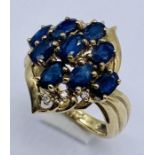A 9ct gold dress ring set with sapphire coloured stones and diamonds