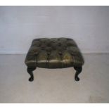 A Victorian green leather upholstered footstool.