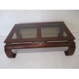 A mahogany coffee table with glass panelled top - overall approx. size length 131cm, width 78cm,