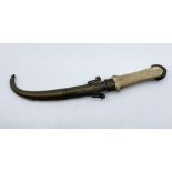 An antique Islamic dagger with bone handle and brass sheath