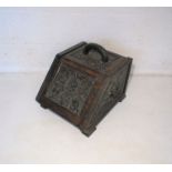 An ornate carved oak coal scuttle.