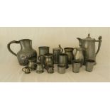 A quantity of antique pewter items, including two large jugs, various tankards etc.