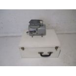 A Thayer & Chandler airbrush compressor with accessories in white painted wooden carry case