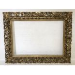 A large carved and gilded ornate 19th Century Florentine frame, overall size 140cm x 180cm