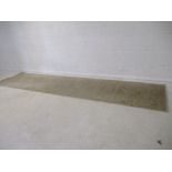 A cream coloured carpet runner. L 304cm, W 75cm