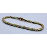 An unmarked 9ct gold (tested) tennis style bracelet set with tourmalines and diamonds, total