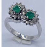 An 18ct white gold ring set with emeralds and diamonds (weight 4.2g)