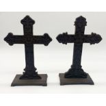 A pair of cast iron crosses on square bases