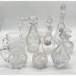 A collection of various cut glass decanters, jugs etc