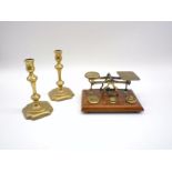 A pair of Georgian brass candlesticks, along with a set of postal scales with weights.