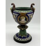 A 19th century Majolica urn with cherub decoration to sides