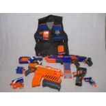 A collection of various sized Nerf Guns, along with bullets and Nerf bodysuit