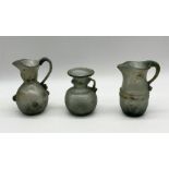 Three small Roman style glass jugs, two with cracks as shown