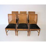 A set of six elm cane backed dining chairs, including one carver.