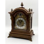 A walnut cased bracket clock with silvered dial, gilt detailing and acorn finial with German