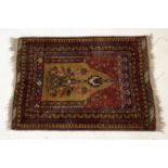 A small red ground Eastern woven prayer rug 114cm x 83cm