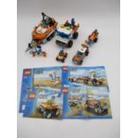 A collection of completed Lego City coast guard vehicles with instruction leaflets including Truck