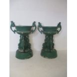 A pair of turn of the century painted cast metal urns with swan pediments, height 103cm.