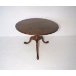 A Georgian mahogany circular tilt-top coffee table, on a turned tripod base with hoof feet, diameter