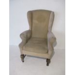 A wingback armchair on turned supports