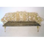 An antique cast iron Coalbrookdale style garden bench decorated with fern leaves, with wooden